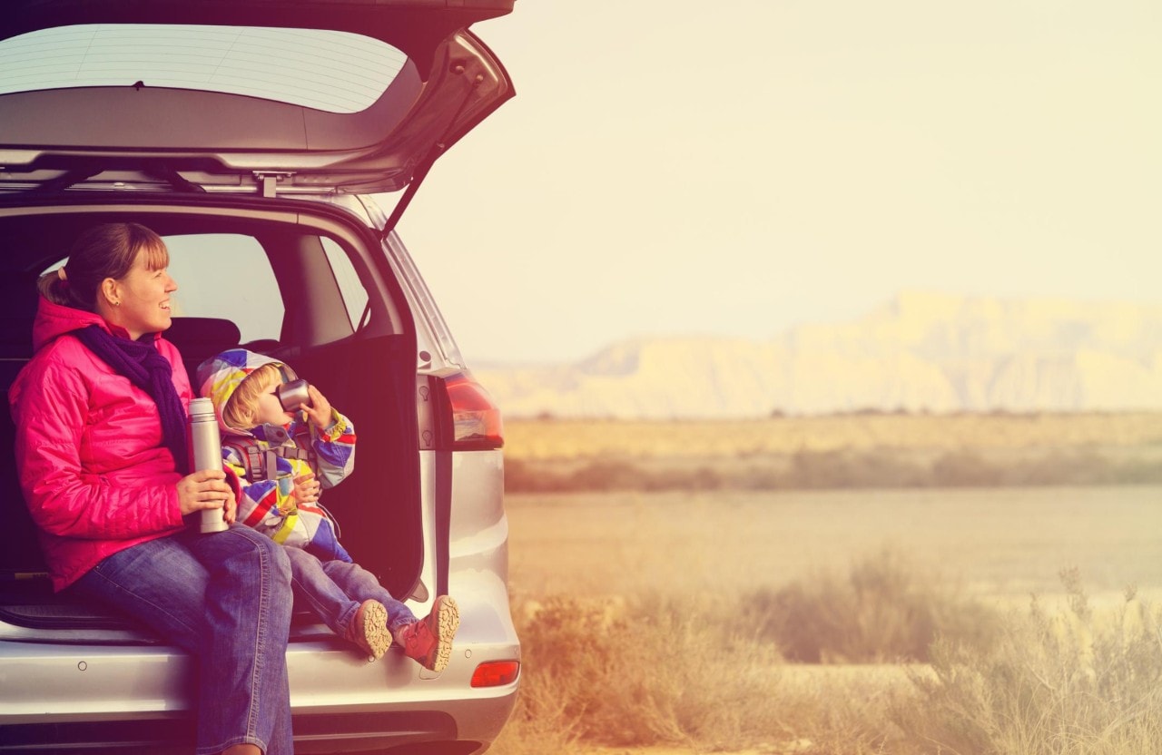 mother and little daughter travel by car in mountains, active family